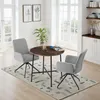 A dining set with a round table and two chairs in a well-lit room with large windows. Produktbild-Vorschau