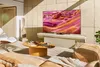 A modern living room with a large TV displaying abstract art. Voir les images du produit