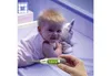 A baby lying on a patterned surface, with a hand holding a thermometer in the foreground. Produktbild-Vorschau