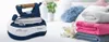 A steam iron and its base are shown on a white surface, with folded towels in the background. Produktbild-Vorschau