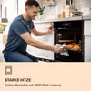 A man is taking a tray of croissants out of a built-in oven. Produktbild-Vorschau