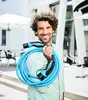 A man is holding an electric vehicle charging cable outdoors. Náhľad obrázku produktu
