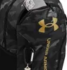 A close-up of a black and gray camouflage backpack with a gold Under Armour logo and a smartphone in a pocket. Náhled obrázku produktu