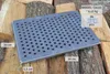A metal grate is placed on a pile of firewood. Náhled obrázku produktu
