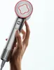 A hand holding a silver hair dryer with a red accent ring. Podgląd zdjęcia produktu