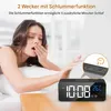 A woman yawning in bed next to a digital alarm clock. Produktbild-Vorschau
