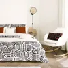 A bedroom scene with a bed, chair, and wall lamp. Produktbild-Vorschau