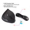A black vertical mouse with a USB charging cable and a mini USB receiver, with text labels pointing to the accessories. Produktbild-Vorschau