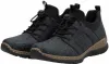 A pair of black sneakers with a textured pattern and brown soles, presented against a white background. Voir les images du produit
