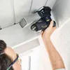 A person is using a Festool Akku-Deltaschleifer DTSC 400 3,0 I-Plus to sand a ceiling or wall. Voir les images du produit
