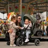 A mother with two young children at a carousel. Produktbild-Vorschau