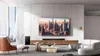 A modern living room with a large TV, soundbar, sofa, and armchair. Náhled obrázku produktu