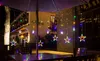 Outdoor seating area at night with decorative star-shaped string lights. Náhled obrázku produktu