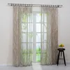 Sheer curtains with a white branch pattern hanging in front of a window. Produktbild-Vorschau