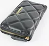 A black quilted wallet with a gold logo is shown on a white background. Produktbild-Vorschau