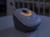 A Philips AVENT audio baby monitor is placed on a table in a dimly lit room. Náhled obrázku produktu