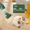 A green handheld vacuum cleaner is shown on a beige carpet next to a sleeping cat on a mat. A graphic overlay indicates a noise level of 70dB. Produktbild-Vorschau