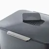 A close-up view of the top of a dark grey waste bin with a silver handle and a small dark grey lid with the 'Joseph Joseph' logo embossed on it. Podgląd zdjęcia produktu