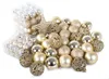 A collection of gold and silver Christmas ornaments, some in clear plastic packaging, scattered on a white surface. Anteprima dell’immagine prodotto