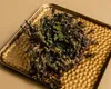 A dried plant on a textured golden tray. Voir les images du produit