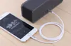 A white iPhone is connected to a black speaker via a white AUX cable. Produktbild-Vorschau