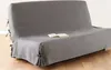 A grey sofa cover is shown on a sofa, with a book placed on top. Produktbild-Vorschau