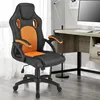 A black and orange gaming chair is shown in an office or home setting. Náhled obrázku produktu