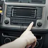 A hand is shown plugging an audio cable into a car's stereo system. Náhled obrázku produktu