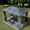 A gazebo set up in a garden with chairs and a table. Podgląd zdjęcia produktu
