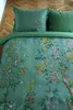 A close-up view of a duvet cover with a floral and bird pattern, laid on a wooden floor. Produktbild-Vorschau
