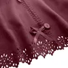 Close-up of a decorative edge of a red fabric item, showing stitching, a bow, and a button. Náhled obrázku produktu