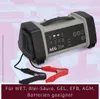 A battery charger with its cables and clamps is shown against a blurred background. Produktbild-Vorschau