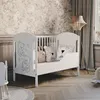 A nursery room with a white crib, decorated with teddy bear motifs, and a patterned wallpaper. Podgląd zdjęcia produktu