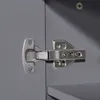 A close-up view of a cabinet hinge attached to a gray cabinet door. Produktbild-Vorschau