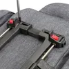 A close-up view of a black KLICKfix accessory holder being attached to a gray fabric surface, possibly a bicycle seat or luggage rack, with a screwdriver in use. Podgląd zdjęcia produktu