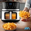 A person is holding a bowl of french fries next to an air fryer. Produktbild-Vorschau