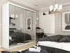 A bedroom scene featuring a large white wardrobe with mirrored doors, a bed with dark bedding, and decorative elements. Produktbild-Vorschau