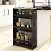 A black four-tier rolling cart filled with jars and bottles, placed next to a kitchen island. Podgląd zdjęcia produktu