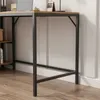 A close-up of a desk leg and part of the tabletop, showing the metal frame and wooden surface. Podgląd zdjęcia produktu