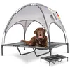 A brown dog is lying on a raised dog bed with a canopy. Produktbild-Vorschau