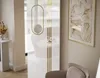 A modern interior scene with a large mirror reflecting a white sofa and a decorative lamp. Produktbild-Vorschau