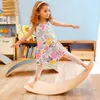A young girl is balancing on a wooden board in a playroom. Produktbild-Vorschau