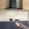 A modern kitchen scene with a black range hood, stovetop, pots, and a hand holding a smartphone. Náhľad obrázku produktu