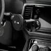A close-up view of a BMW M Edition wireless car charger mounted on a car's dashboard. Podgląd zdjęcia produktu