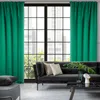 A living room scene with a sofa, coffee table, and large window with green curtains. Produktbild-Vorschau