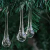 Three clear glass icicle ornaments hang from a green Christmas tree branch. Produktbild-Vorschau