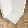 A white square shower tray with a drain is installed in a corner of a bathroom with a wooden floor. Produktbild-Vorschau