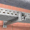 A metal cable tray system is mounted to a brick wall, with a concrete ceiling above. Náhľad obrázku produktu