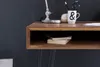 A close-up view of a wooden desk with a shelf and a lamp. Produktbild-Vorschau