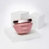 A pink Kérastase hair mask is displayed on a white pedestal against a white and light gray background. Produktbild-Vorschau